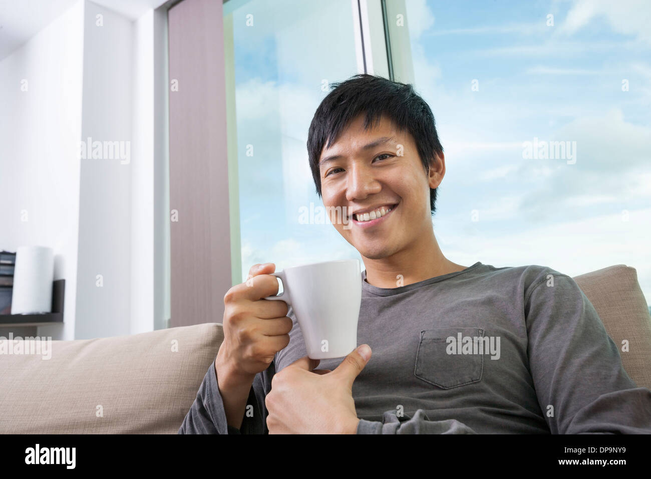 Portrait of mid adult man holding coffee cup in house Stock Photo