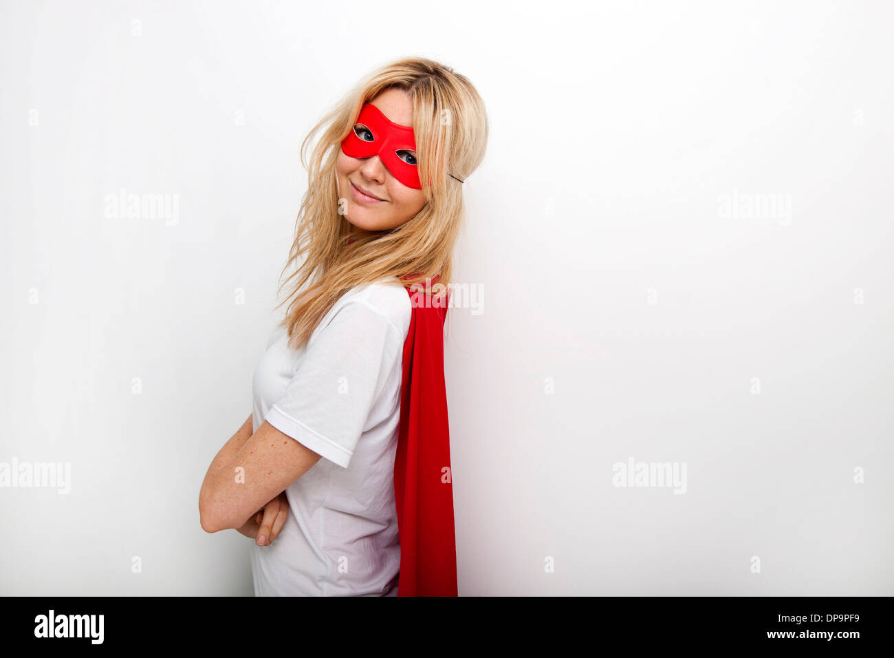 Side view portrait of confident woman in superhero against white background Stock Photo