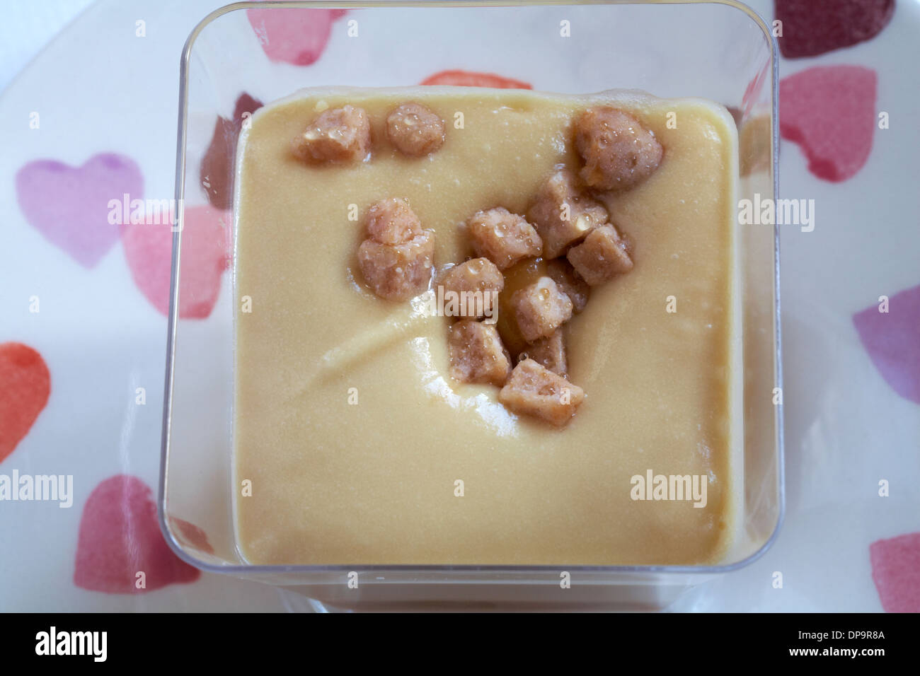 Tesco finest sticky toffee desserts with yorkshire fudge pieces set on plate with hearts on Stock Photo