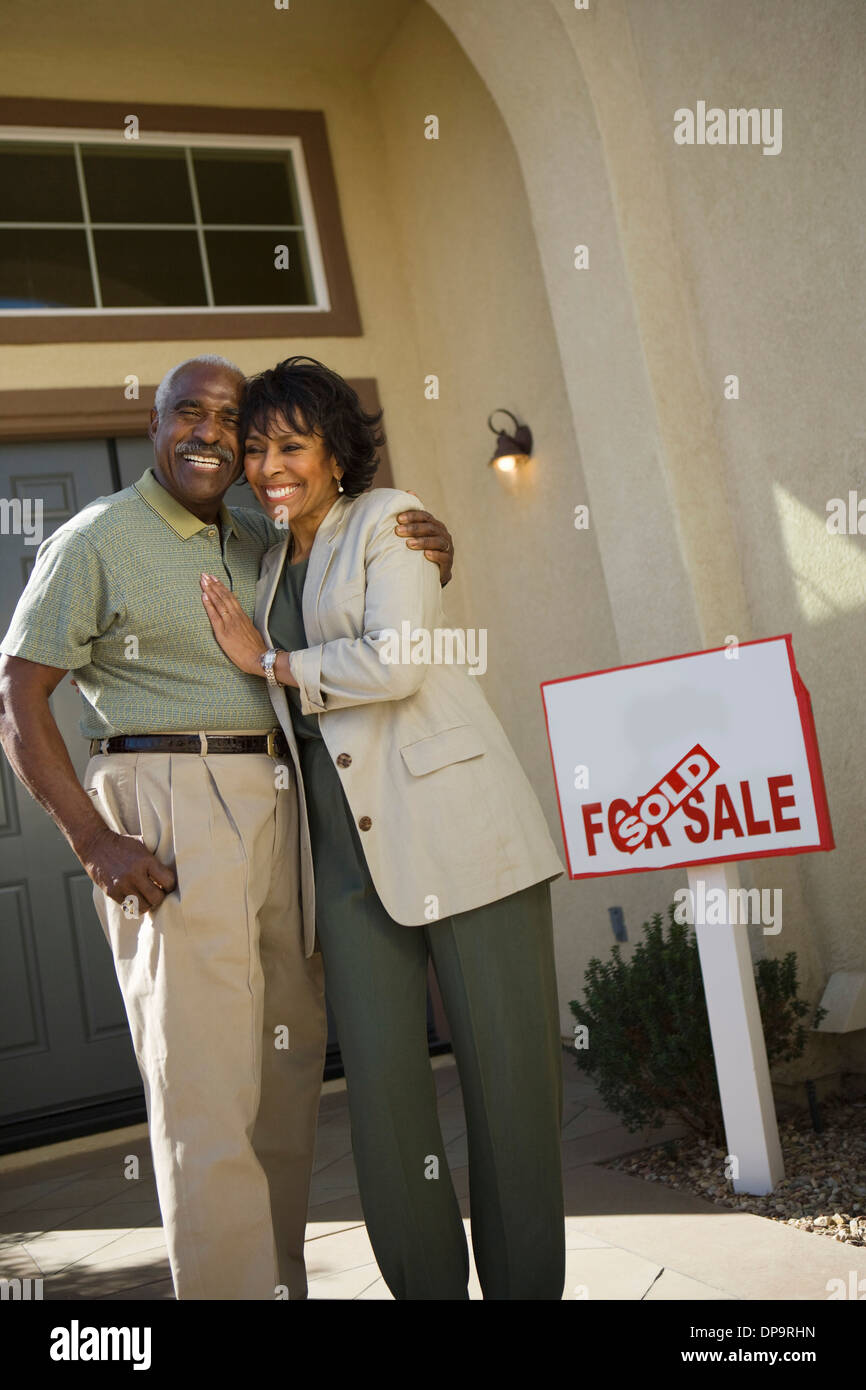 Middle-aged couple in front of new home Stock Photo - Alamy