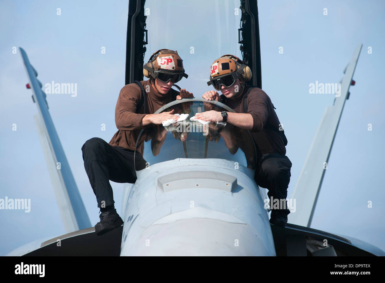 U.S. Navy Airmen polish the canopy of an EA-18G Growler Stock Photo