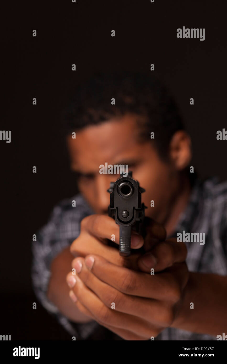 Robbery in store. Robber is aiming and threatening with gun in shop. Stock  Photo