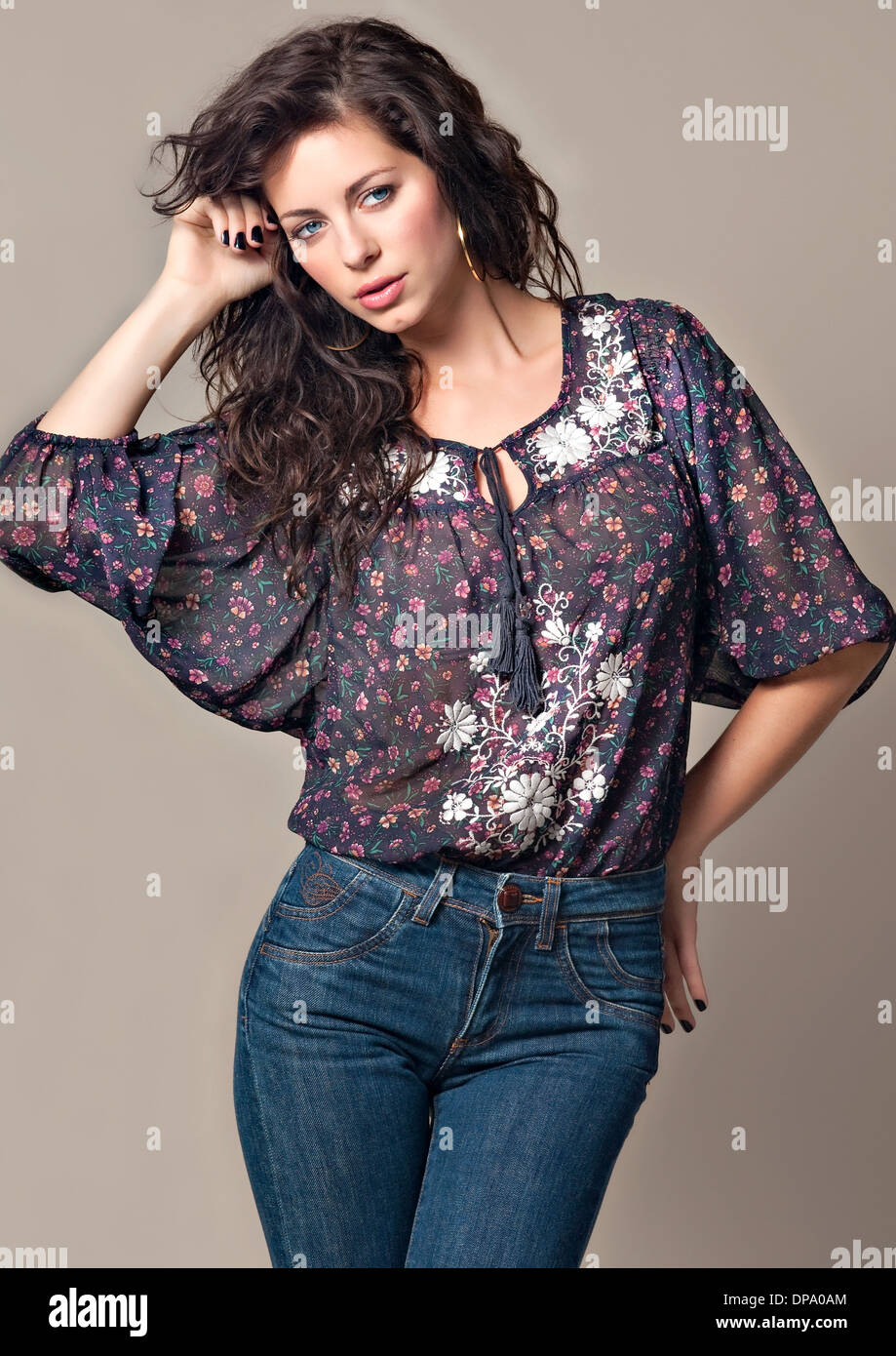 A beautiful woman, female model posing in Spring Casual feminine clothing and blue jeans Stock Photo