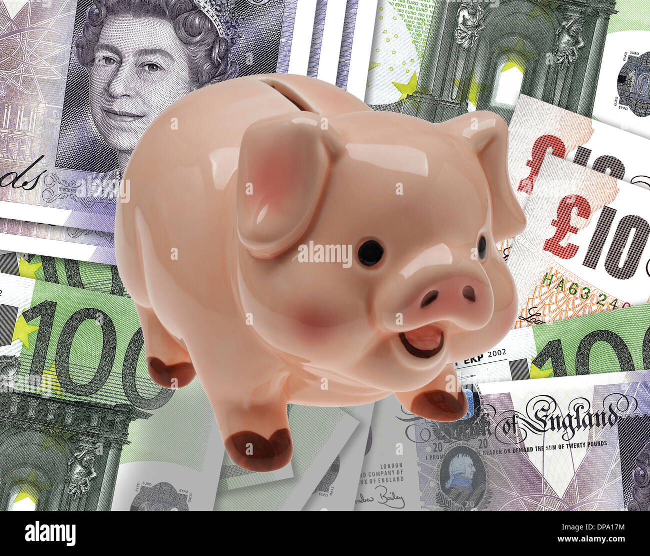 China/ceramic child’s savings or piggy bank on background of pound and euro currency. Stock Photo