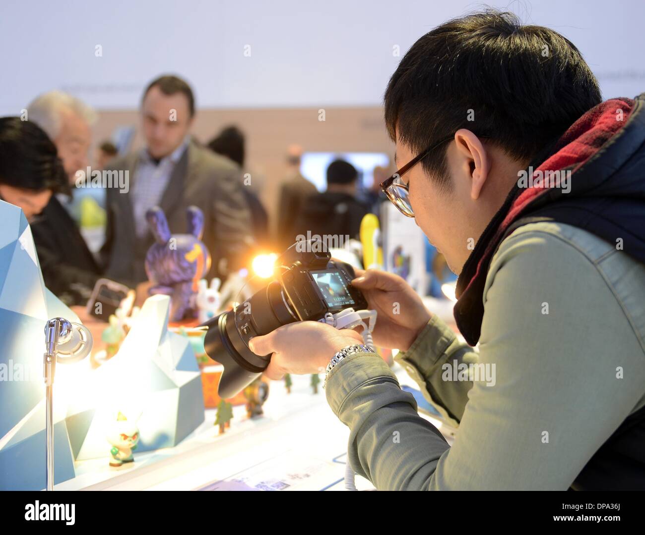 Las Vegas, united states of America. 09th Jan, 2014. A visitor of the fair looks at the Samsung camera NX30 during the CES (Consumer Electronics Show) in Las Vegas, united states of America, 09 January 2014. The fair runs from 07 to 10 January 2014. Photo: Britta Pedersen/dpa/Alamy Live News Stock Photo