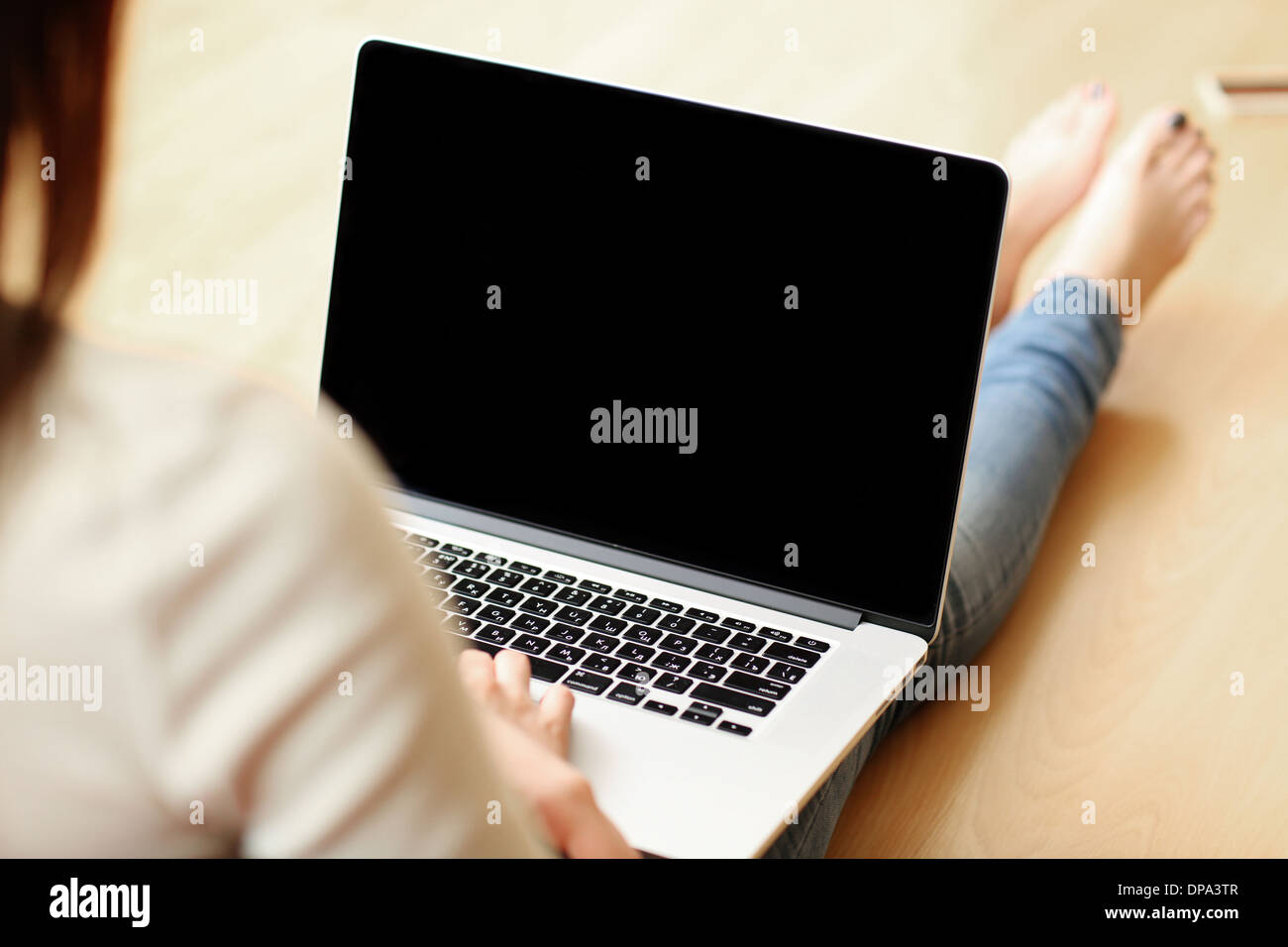 Woman holding laptop with blank screen Stock Photo
