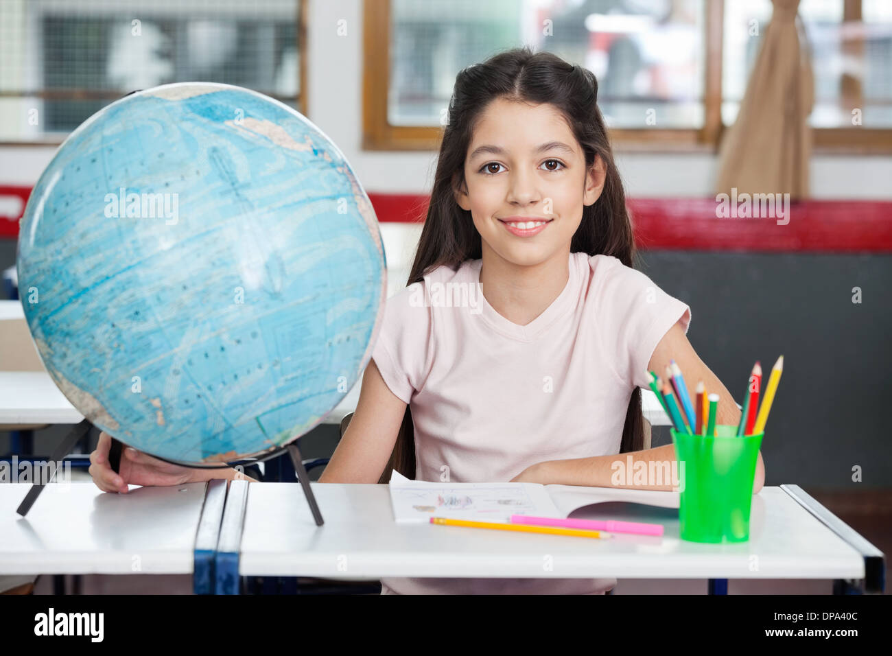 Schoolgirl Smiling With Globe Stock Photo - Alamy