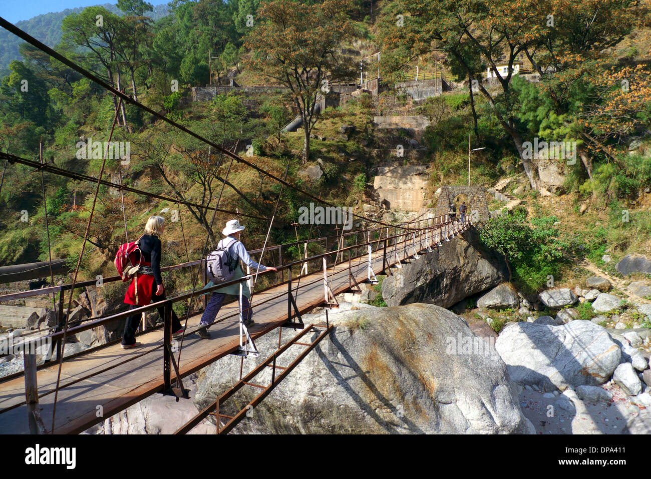 Trekkers cross suspension bridge at Gehra, nr Mcleodganj, Himachal Pradesh, Northern India. Stock Photo