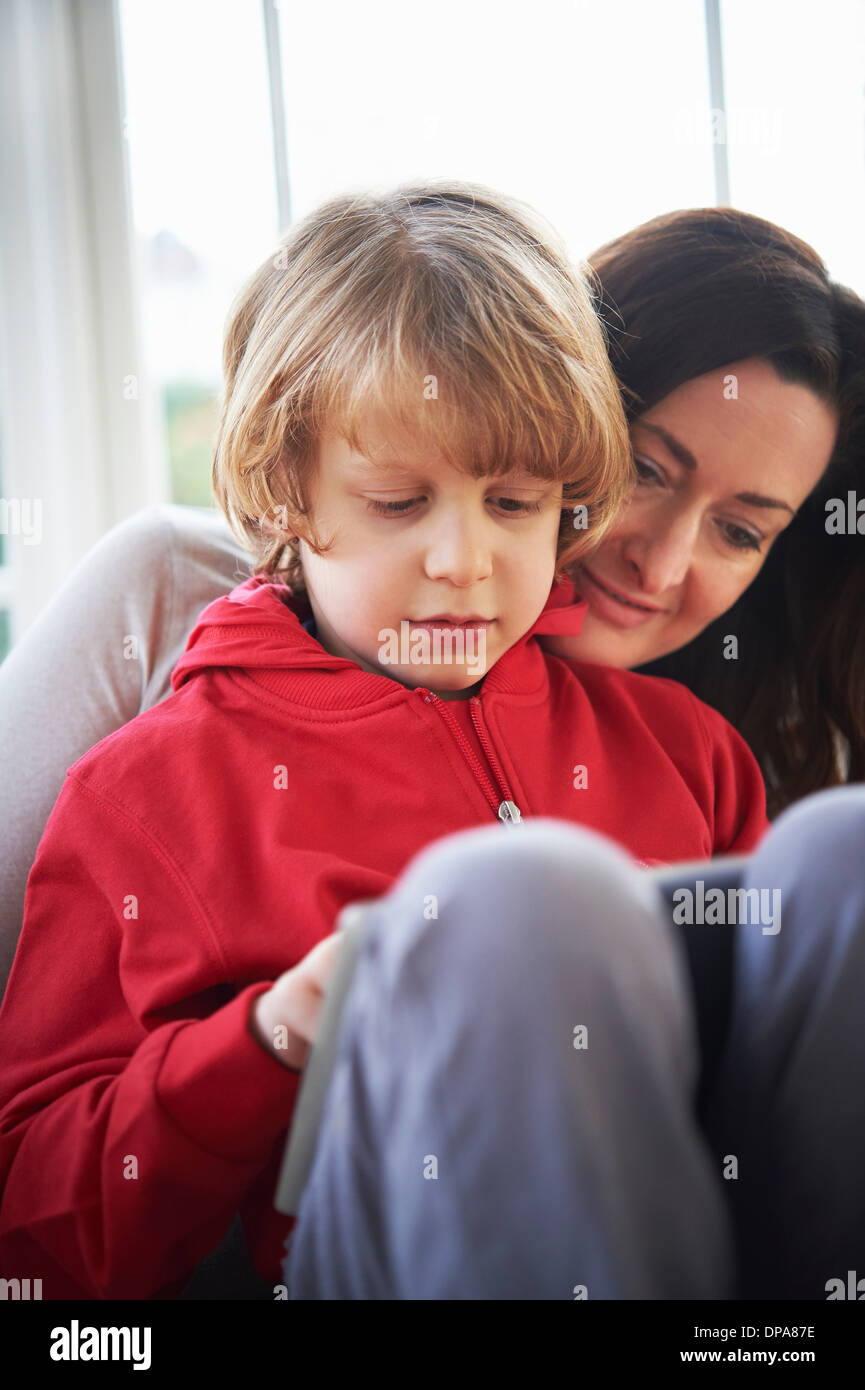 Mother and son on sofa using digital tablet Stock Photo