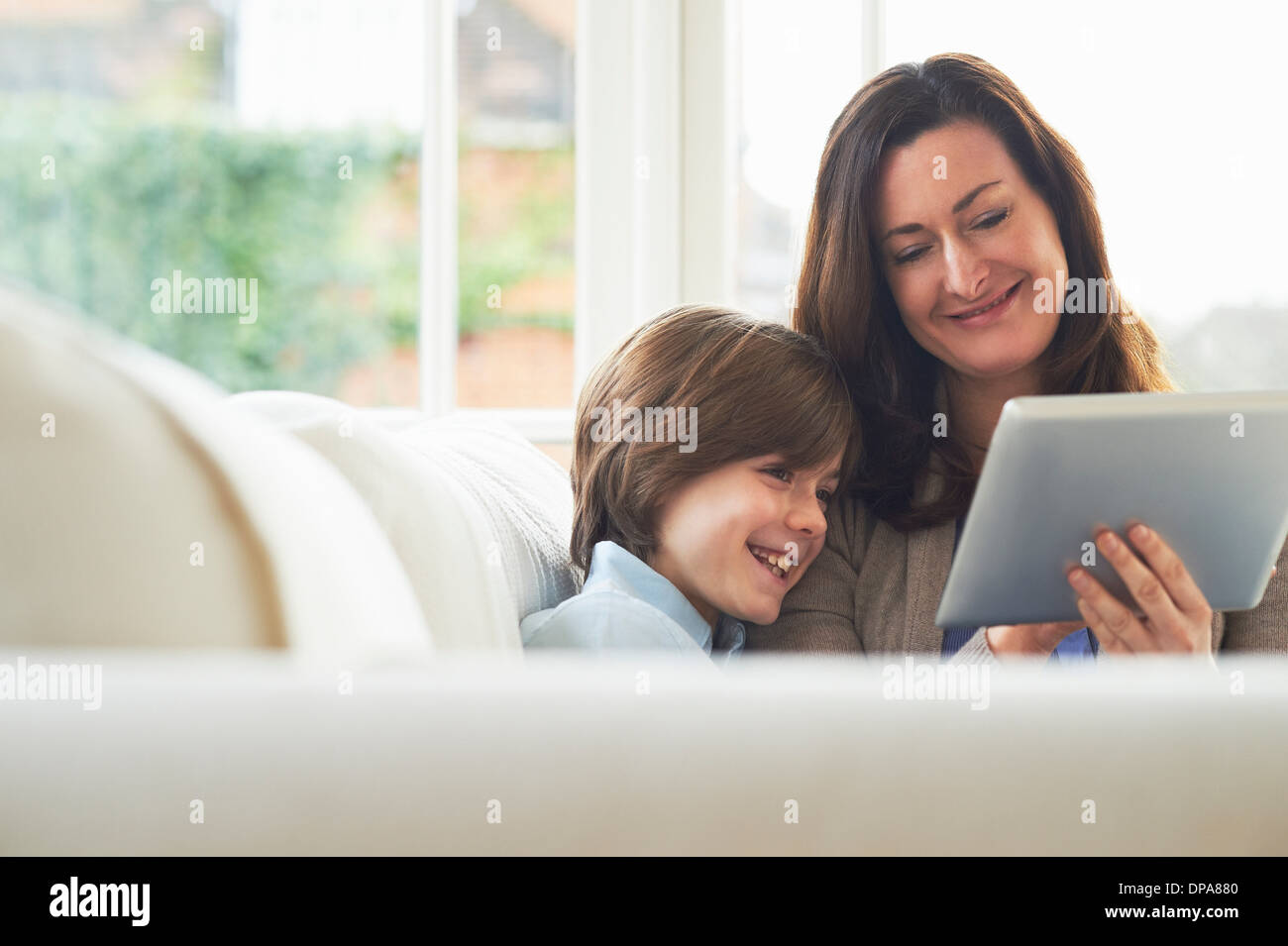 Mother and son on sofa using digital tablet Stock Photo