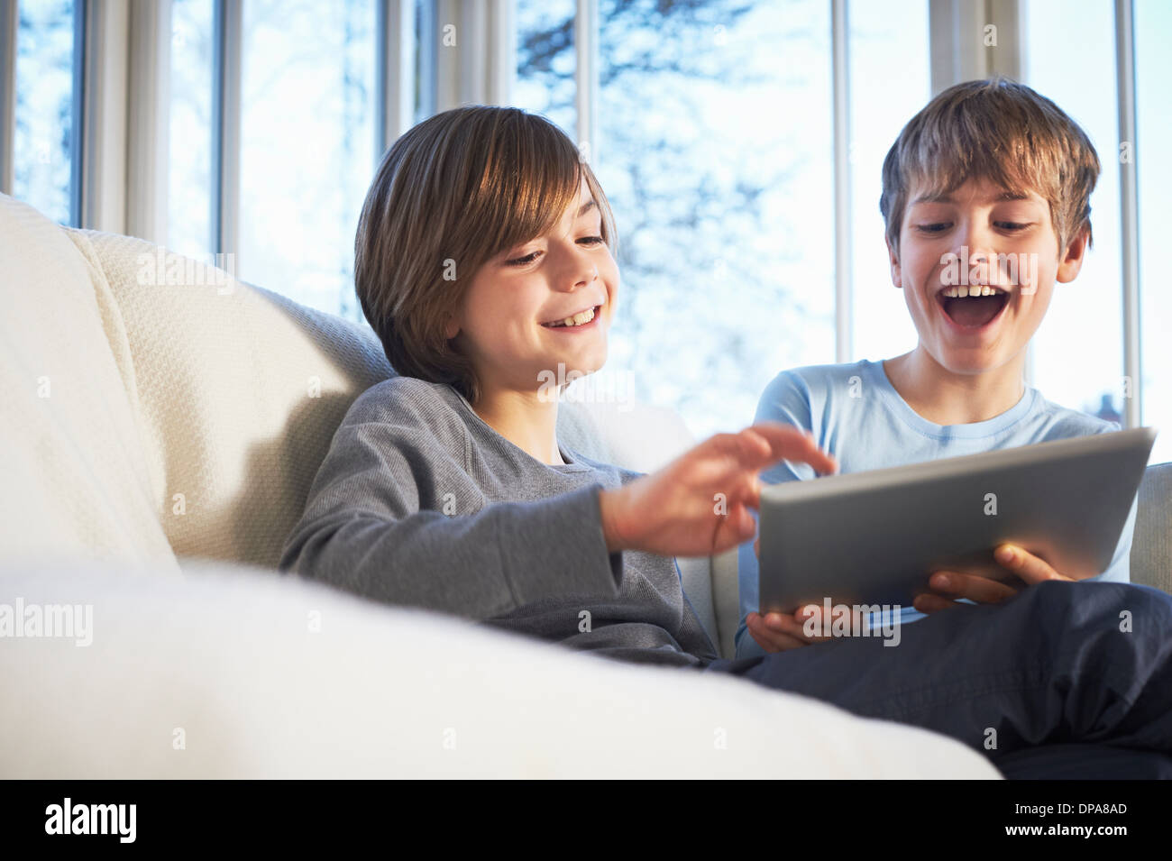 Brothers using digital tablet together Stock Photo