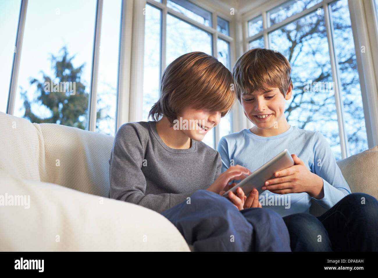 Brothers using digital tablet together Stock Photo