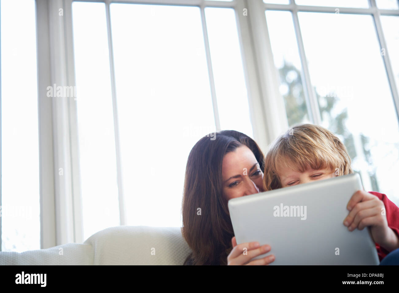 Mother and son on sofa using digital tablet Stock Photo