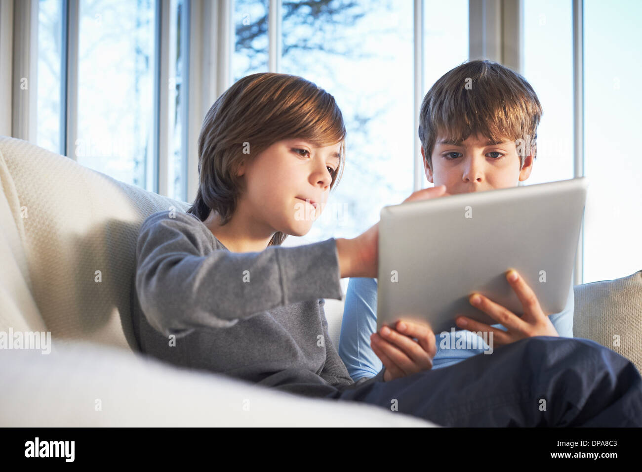 Brothers using digital tablet together Stock Photo