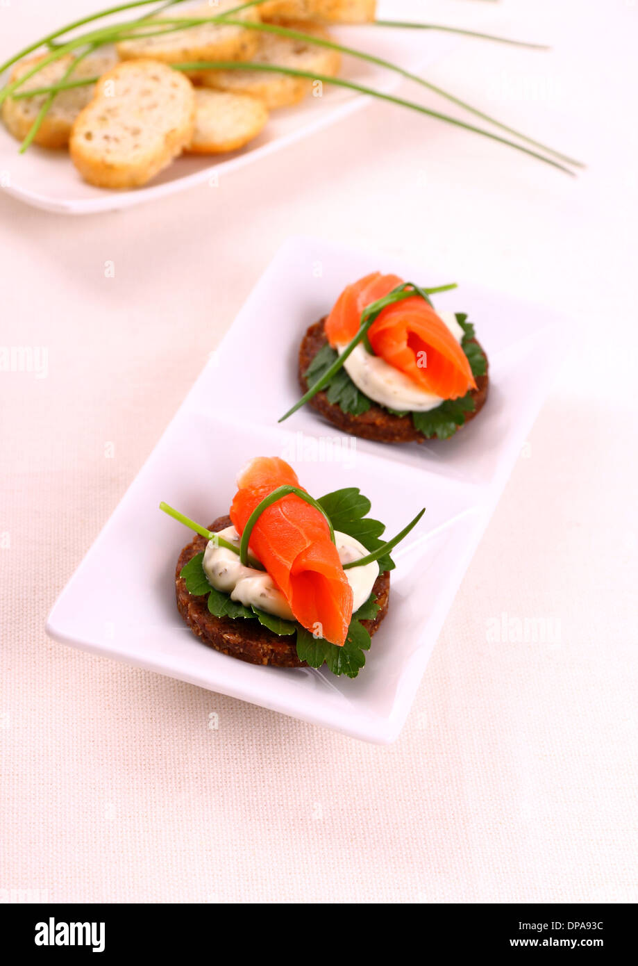 Smoked salmon roll on pumpernickel bread and remoulade, top view Stock