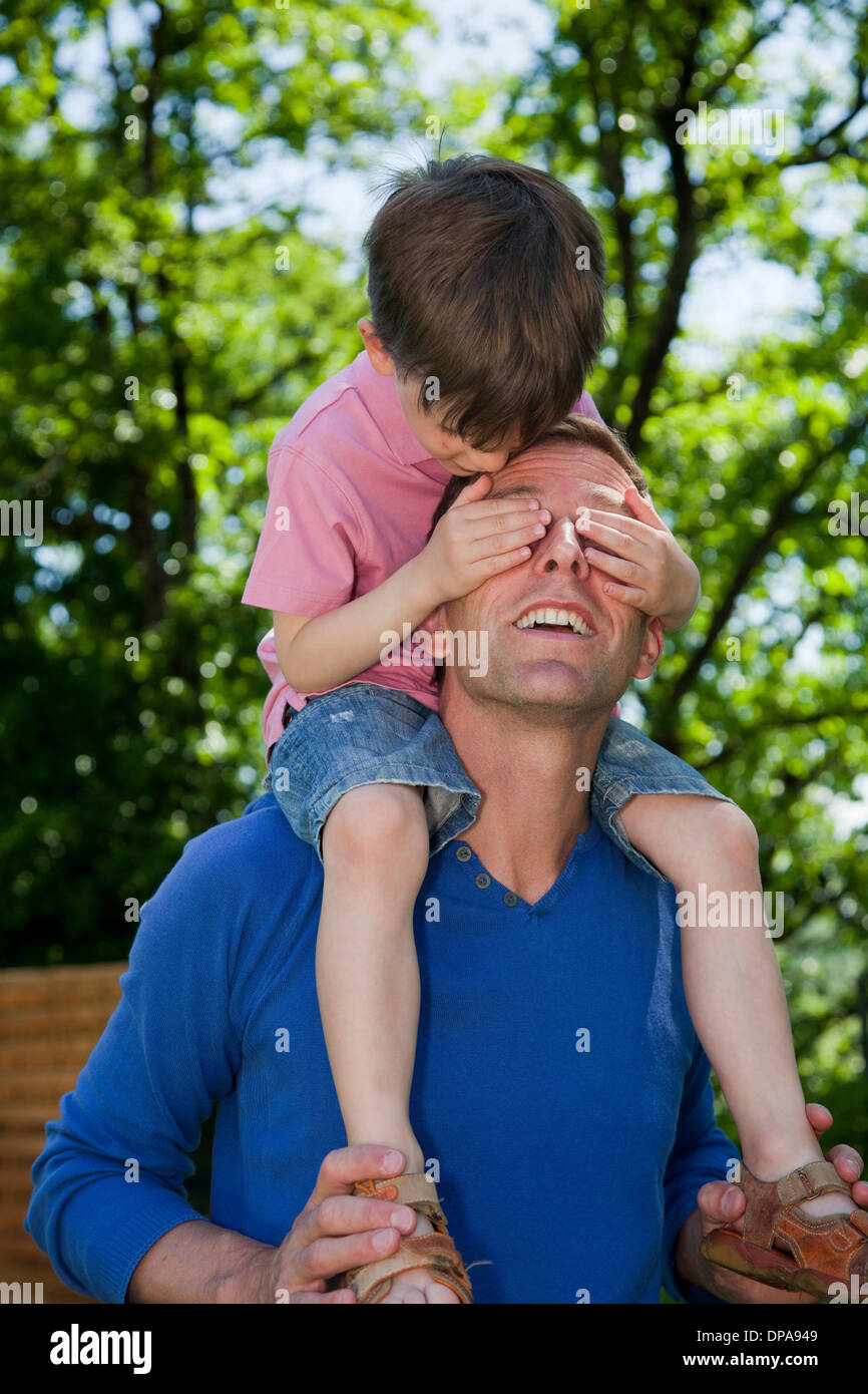 Child riding piggy back on father Stock Photo