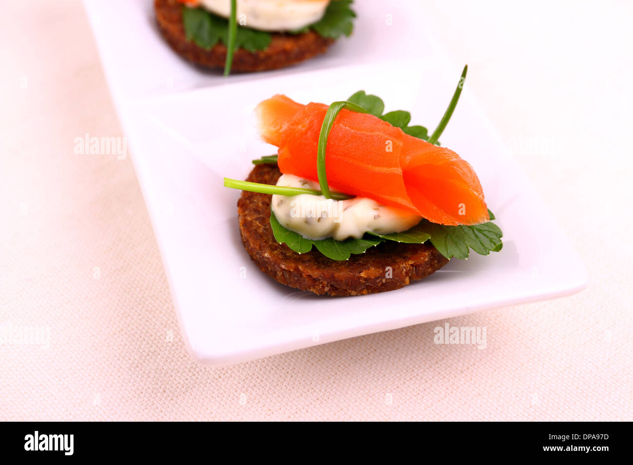 Smoked salmon roll on pumpernickel bread with remoulade, close up Stock