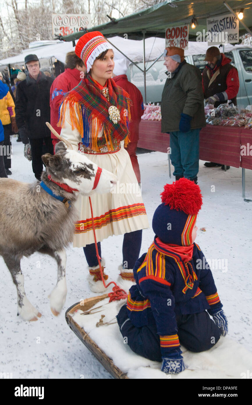 Traditional Reindeer caravan with people dressed in Same Folk costume at Jokkmokk fair Laponia Sweden Winter Stock Photo
