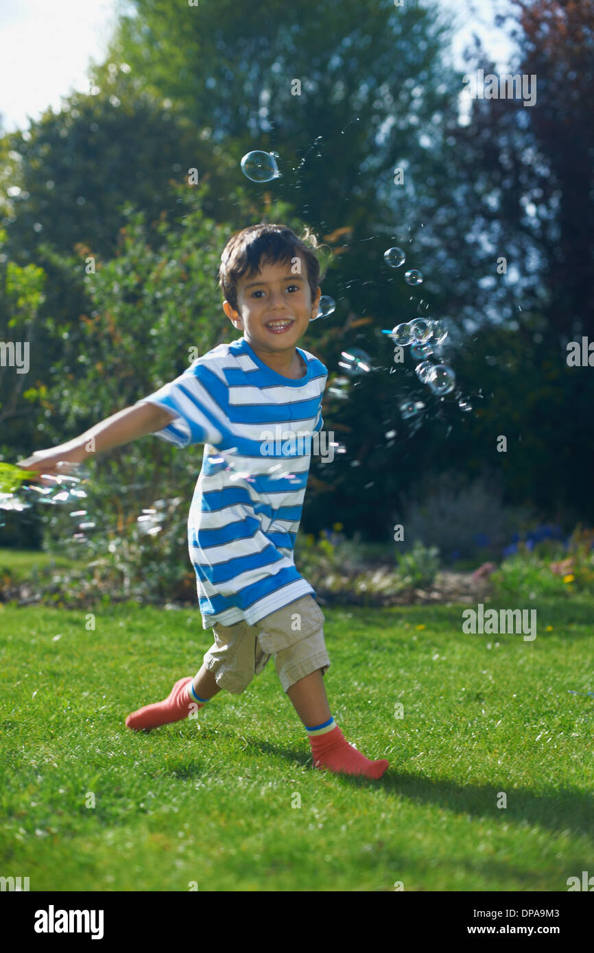 Boy playing with bubbles in garden Stock Photo