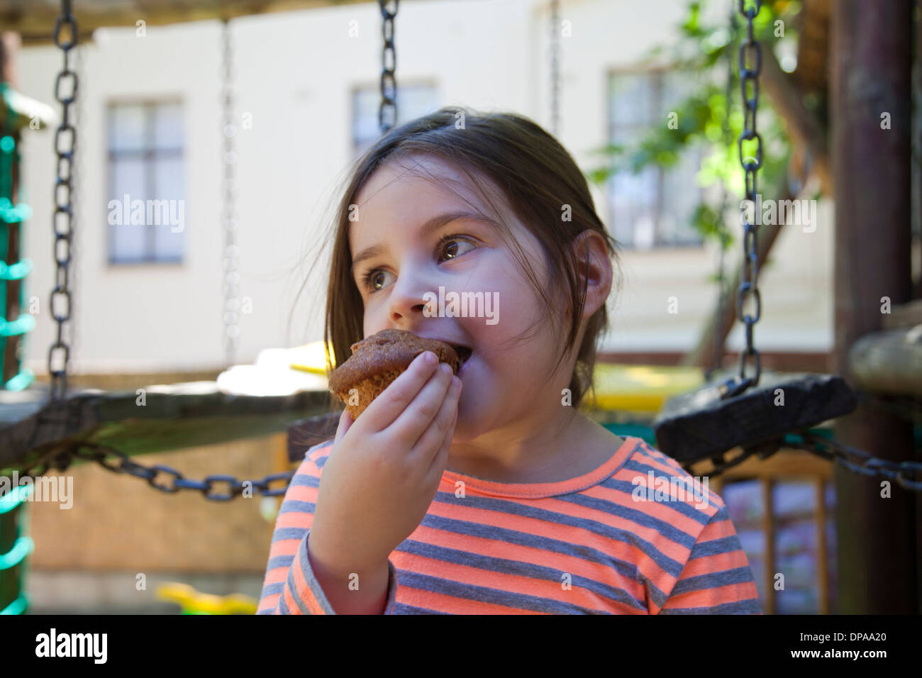 Girl in Playground Eating Cupcake Stock Photo