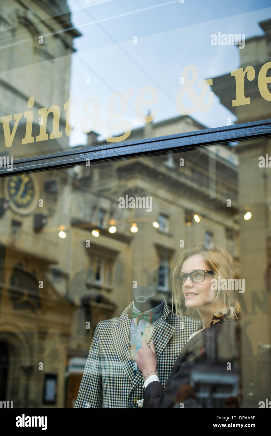 Woman putting jacket on shop dummy Stock Photo