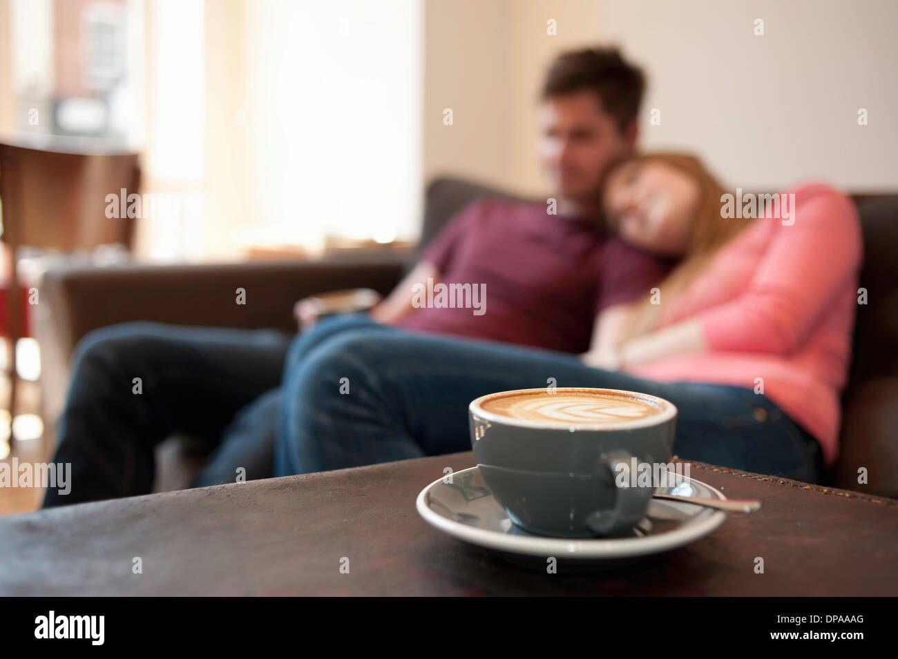 Young couple lounging on cafe sofa Stock Photo