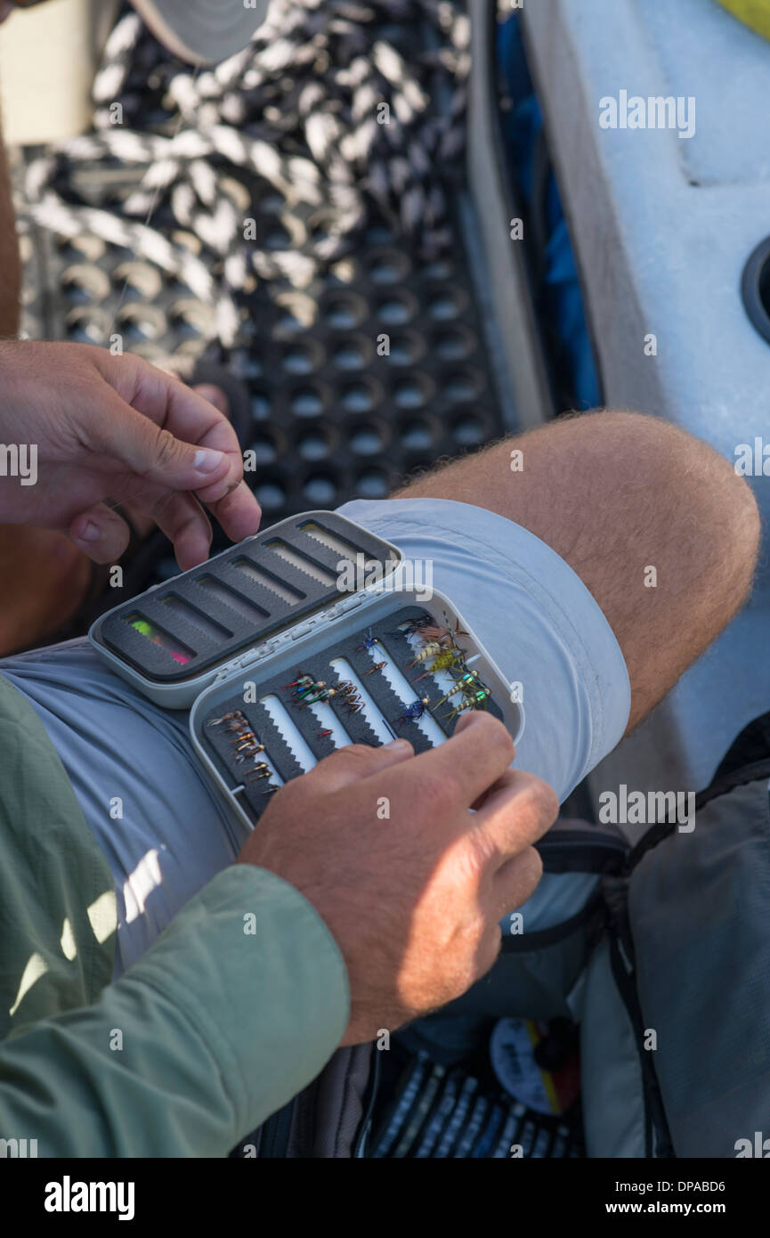 Fly-fishing guide with fly box in a boat Stock Photo