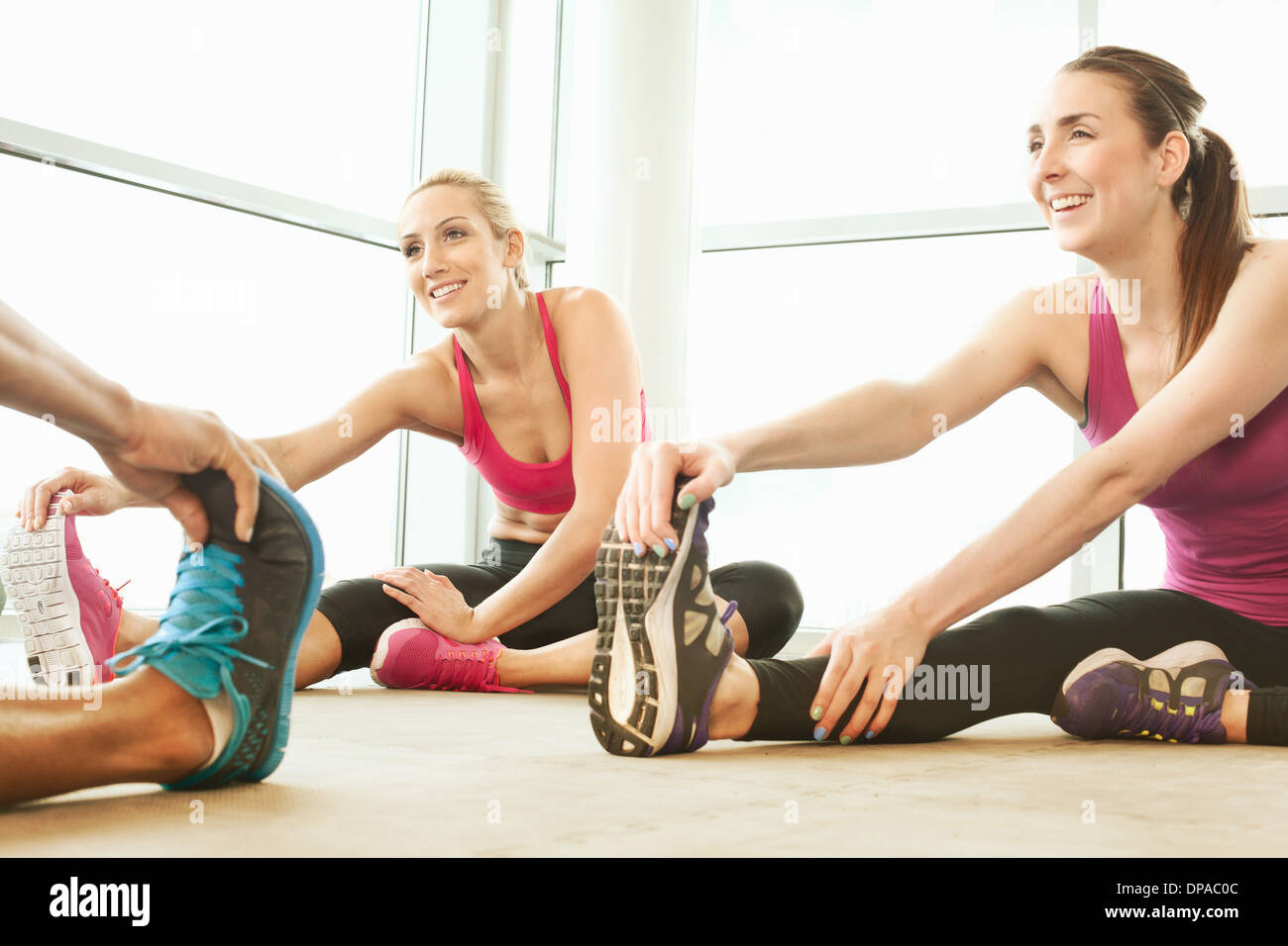 Friends stretching in gymnasium Stock Photo