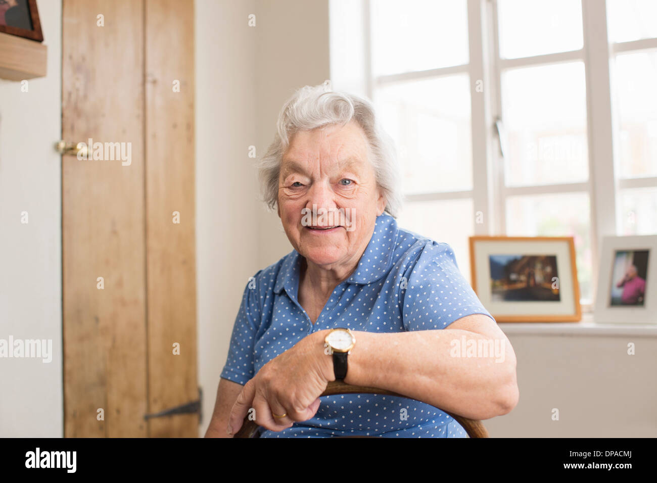 Senior adult woman sitting in room Stock Photo