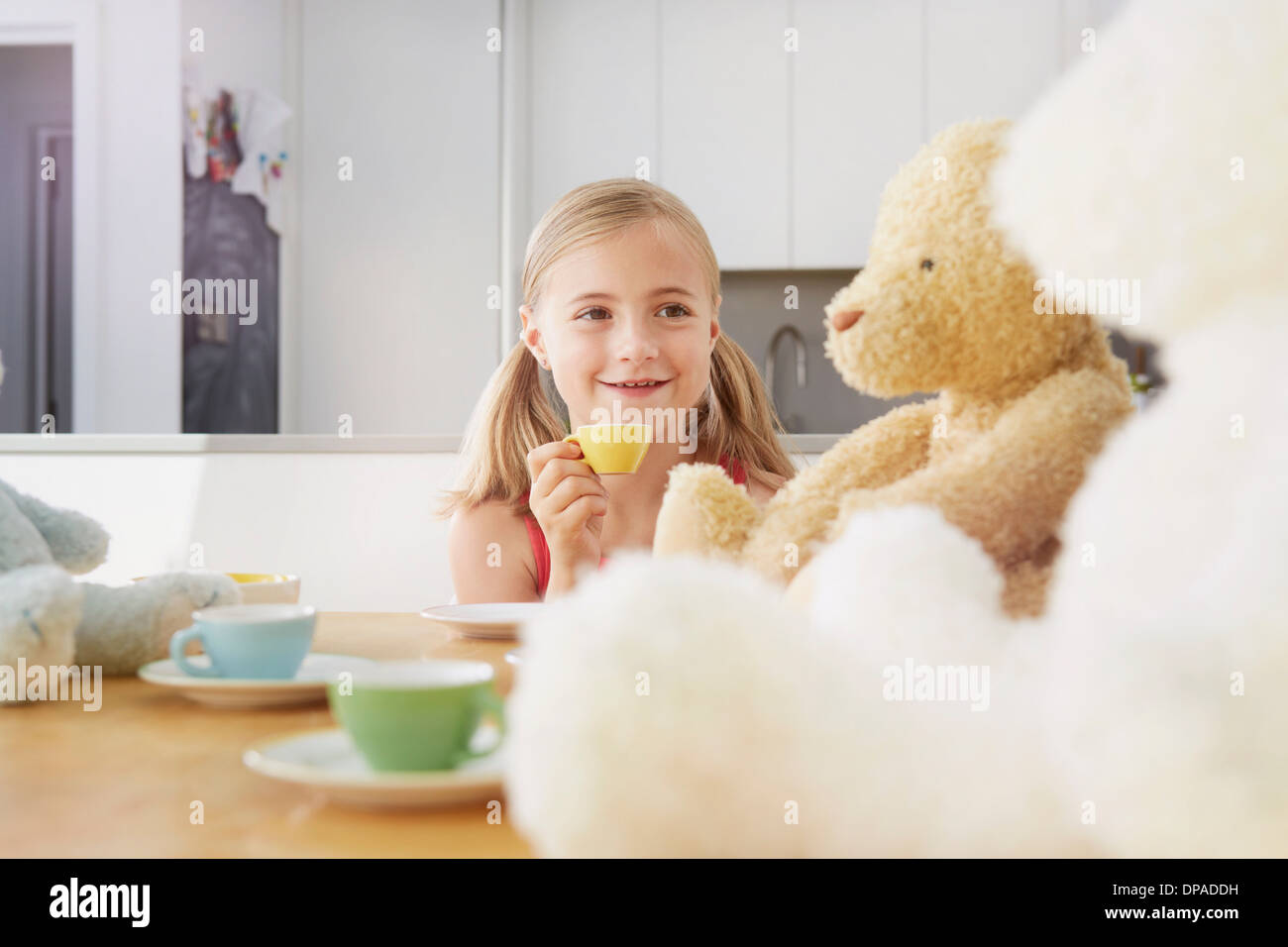 Girl having tea party with soft toys Stock Photo - Alamy