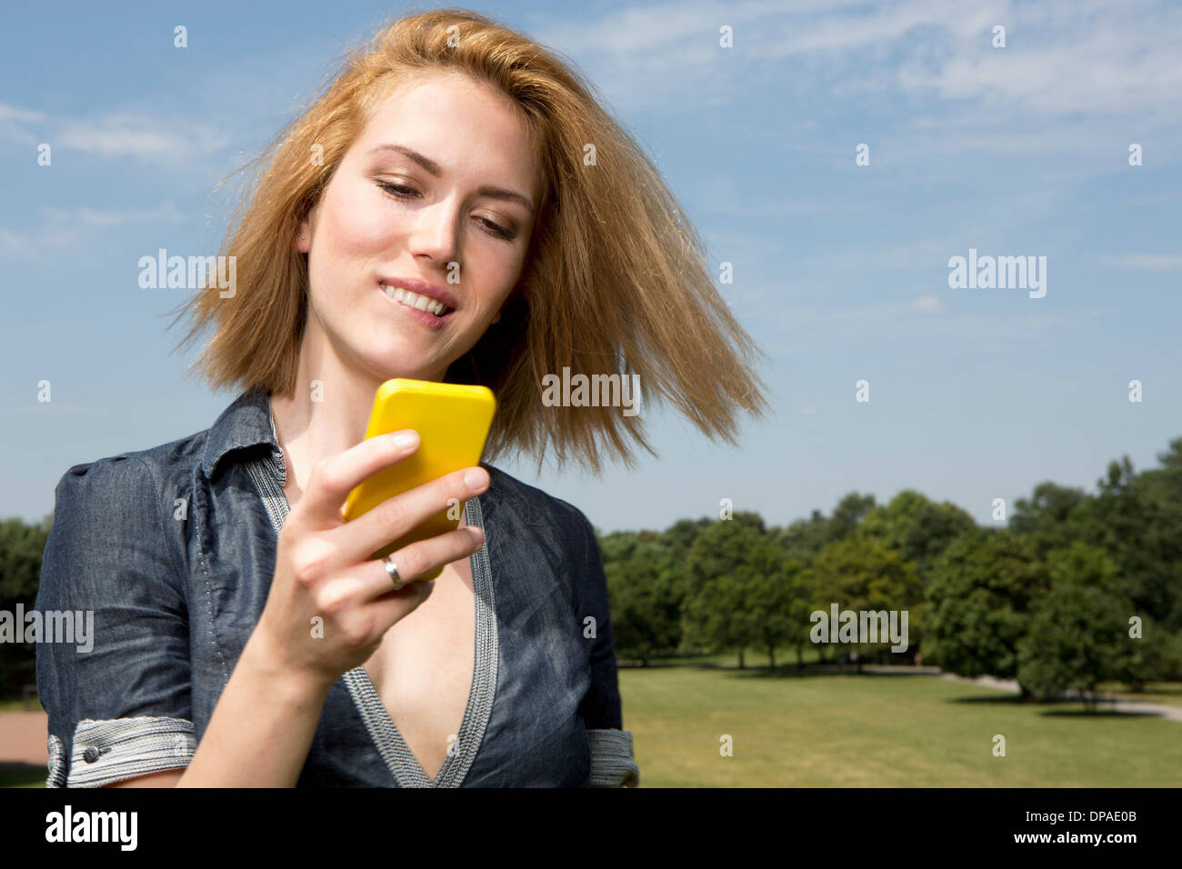 Young woman using smartphone in park Stock Photo