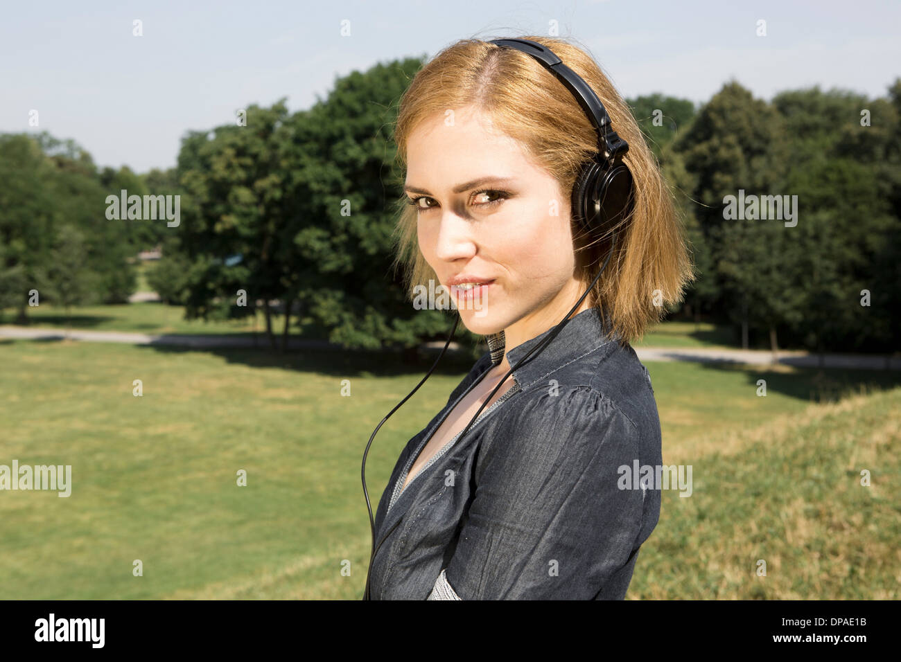 Young woman wearing headphones in park Stock Photo