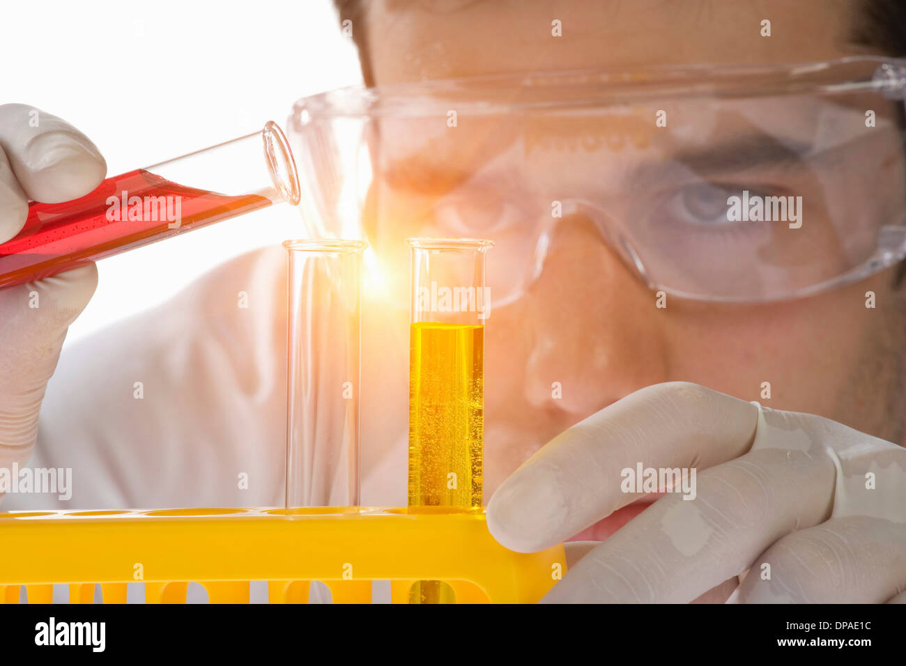 Close up of scientist pouring liquid into test tube Stock Photo