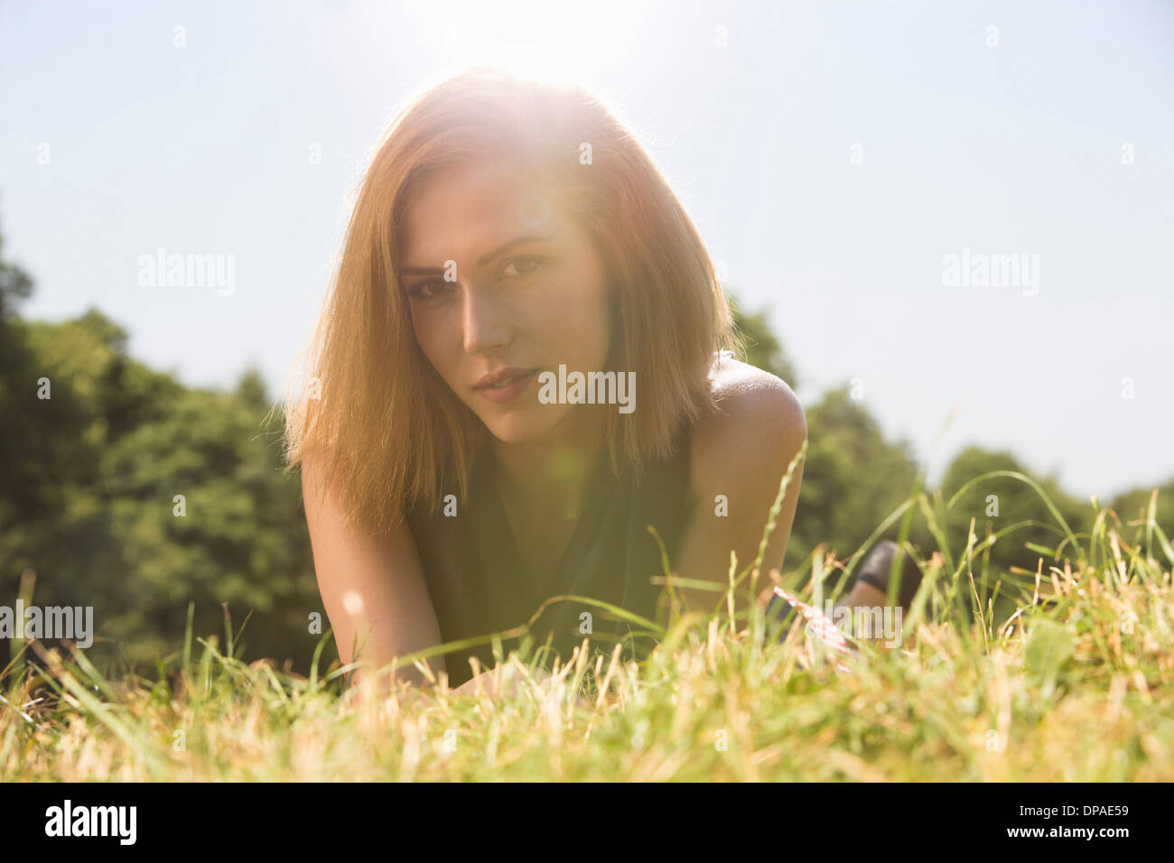 Young woman relaxing in park in sunlight Stock Photo