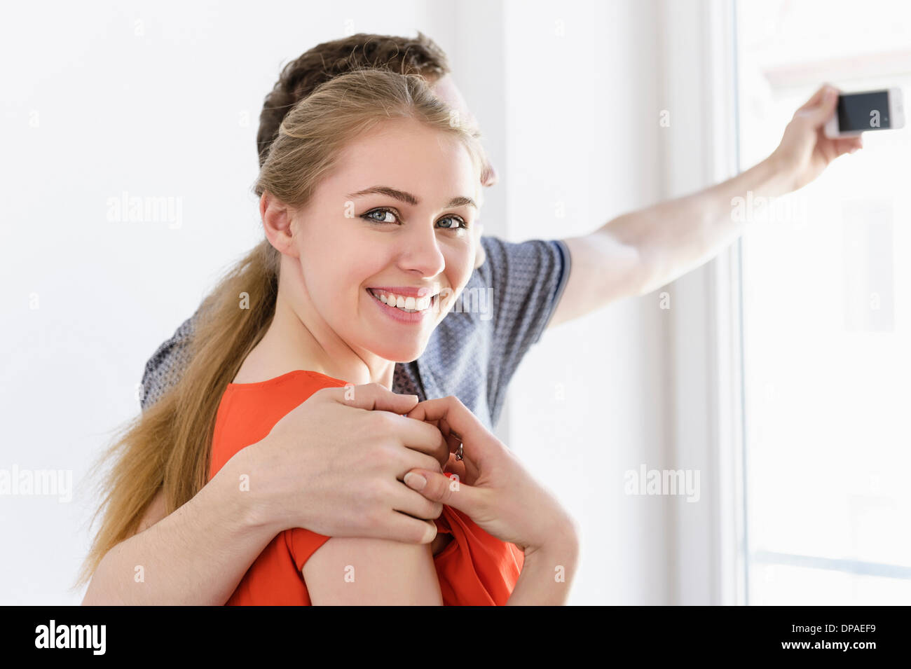 Close up of young couple taking photograph from window Stock Photo