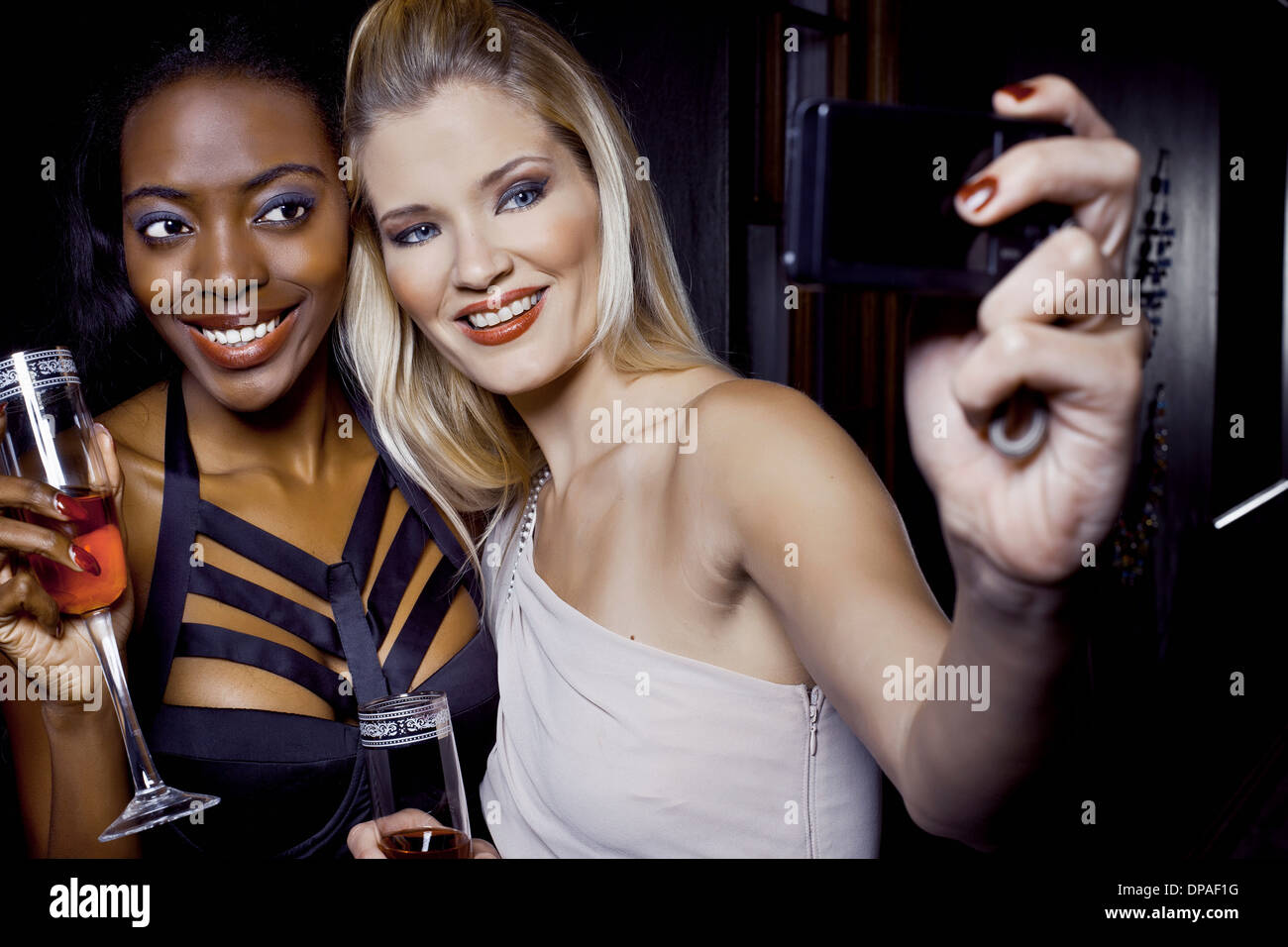Two female friends making self portrait in nightclub Stock Photo - Alamy