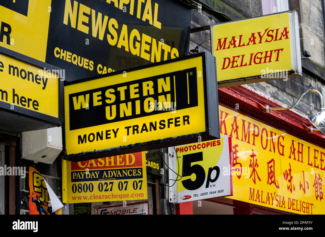 A Western Union sign surrounded by a plethora of predominantly yellow signs. Stock Photo