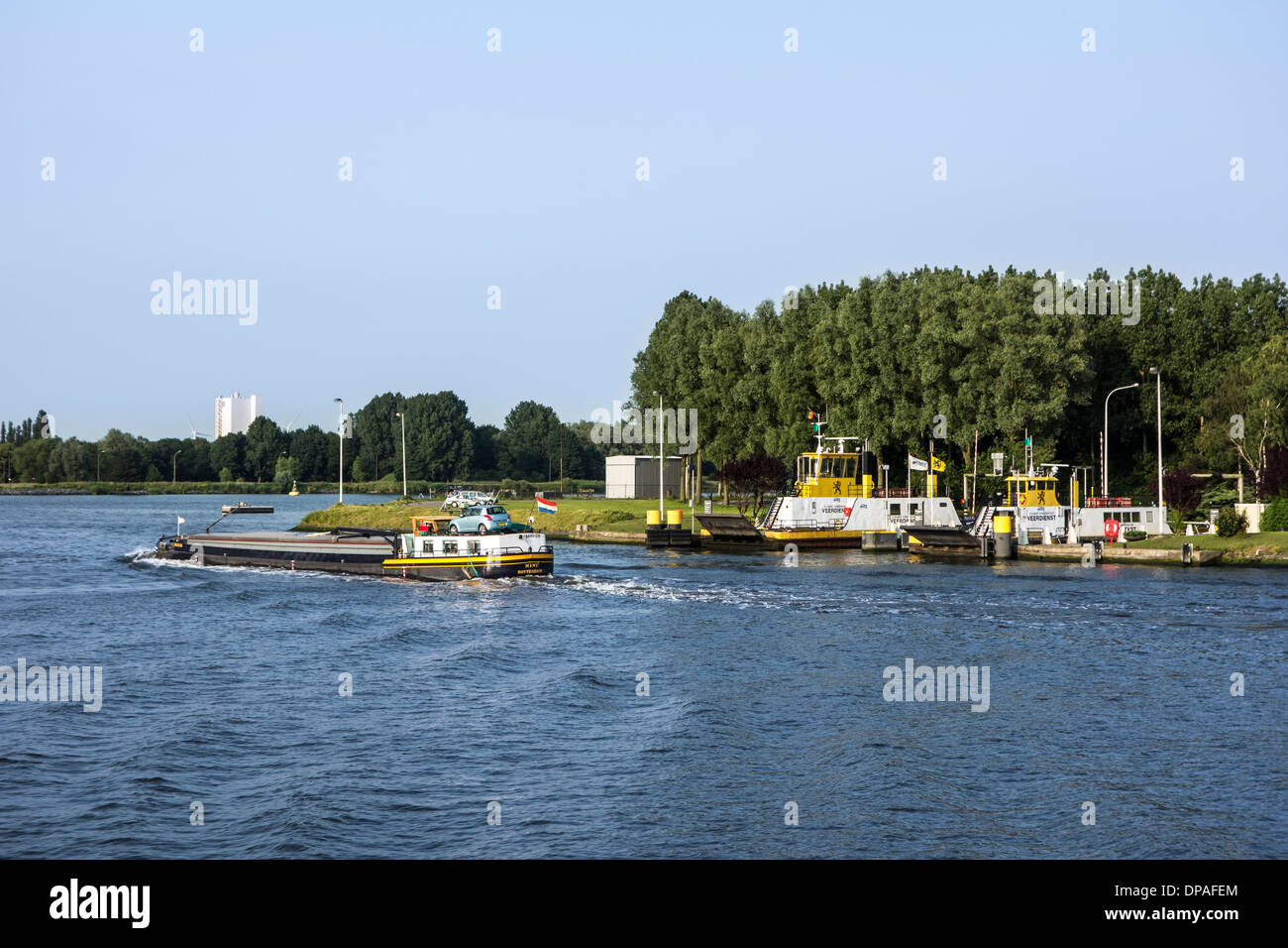 Inland vessel sailing past the Langerbrugge car ferry service in the port of Ghent, East Flanders, Belgium Stock Photo