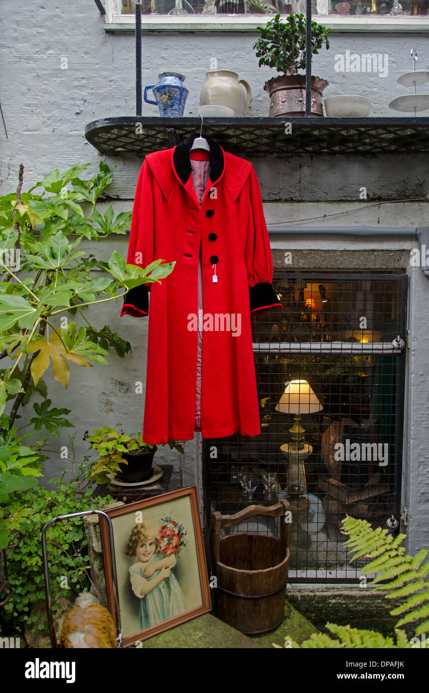 A red coat amongst various other items on display outside an antique shop In Edinburgh's New Town. Stock Photo