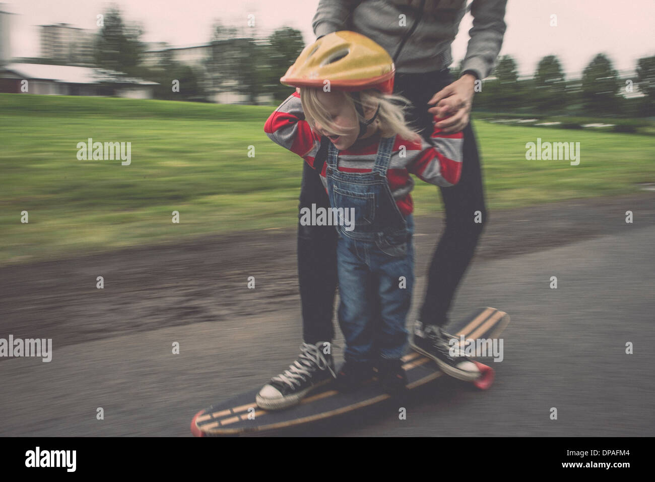 Mother and daughter riding on skateboard in park Stock Photo