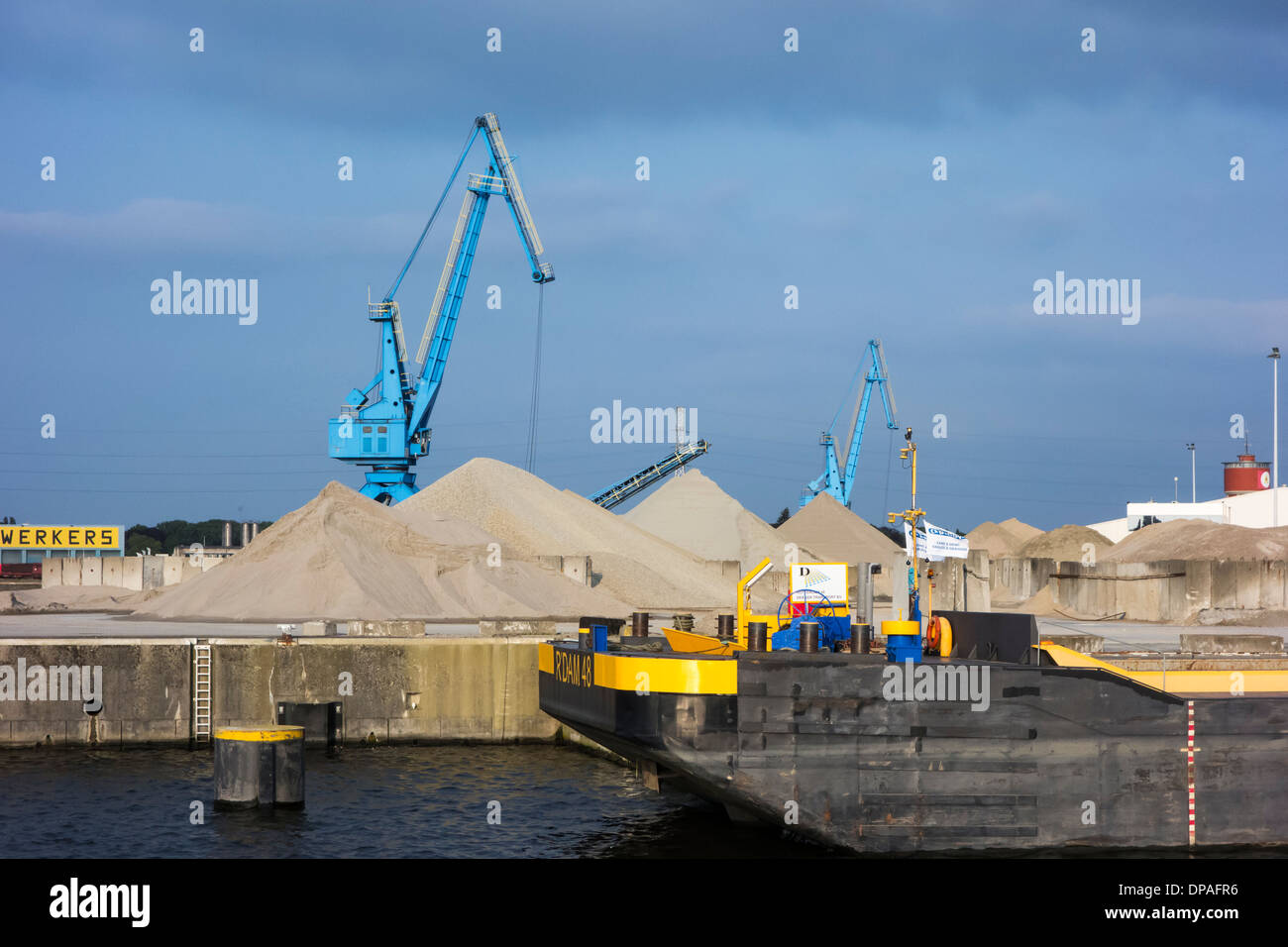 Dock cranes and heaps of sand at the Ch. Kesteleyn gravel terminal in the port of Ghent, East Flanders, Belgium Stock Photo
