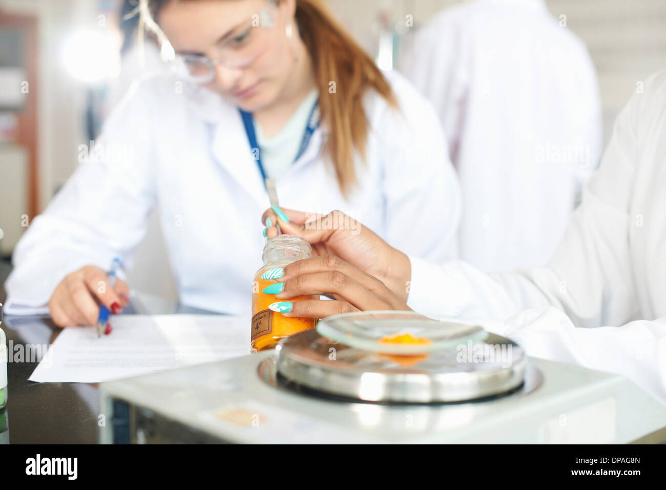 Chemistry students weighing chemicals on scales Stock Photo Alamy