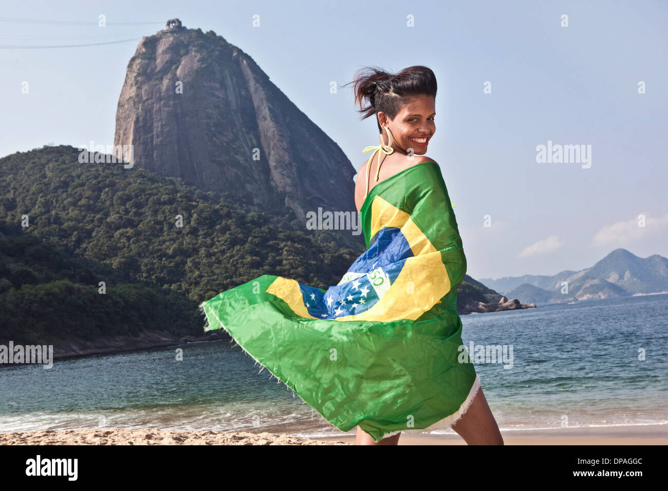 Man on beach with Brazilian flag, Rio de Janeiro, Brazil Stock Photo