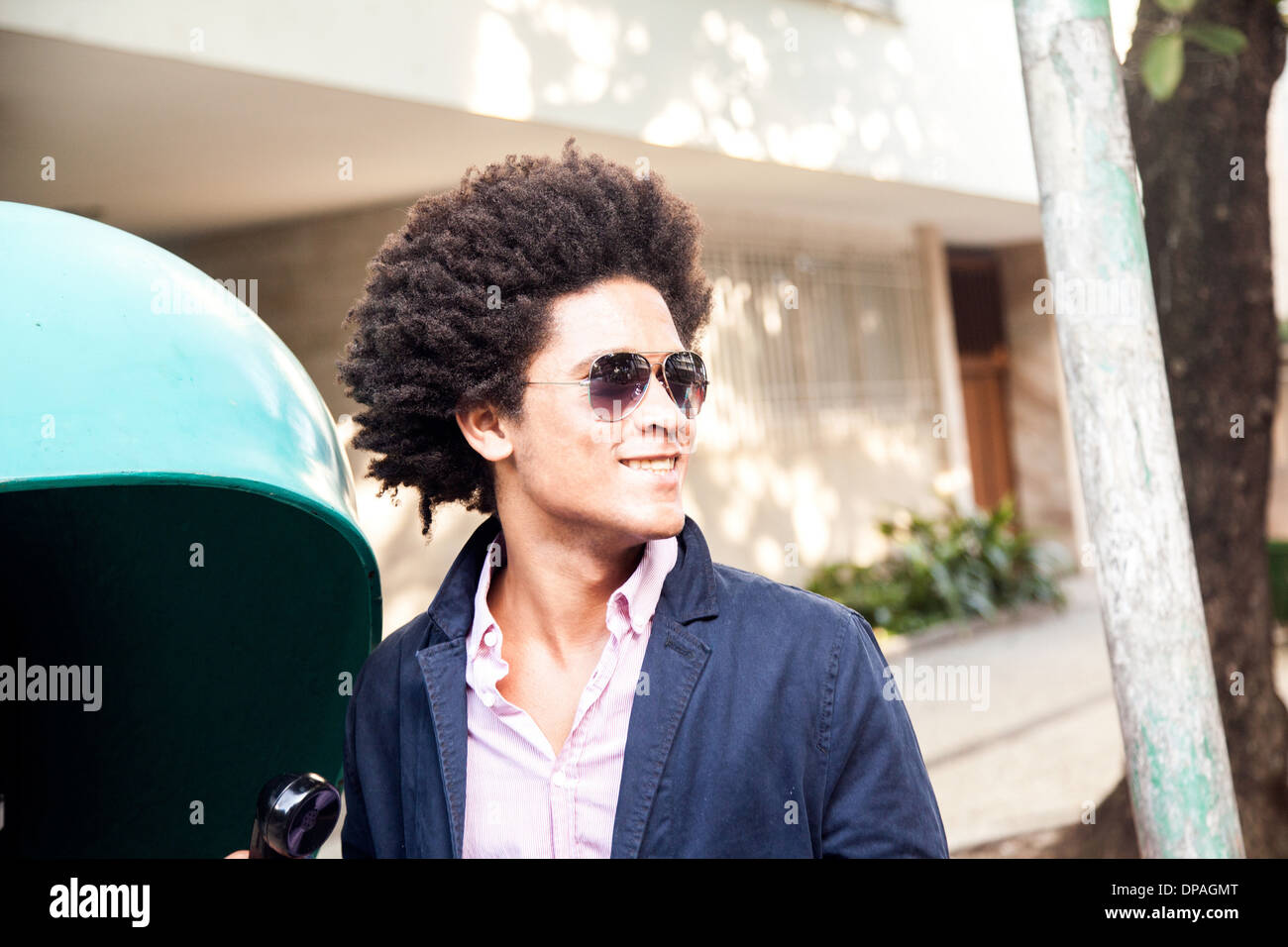 Young man in sunglasses by pay telephone Stock Photo