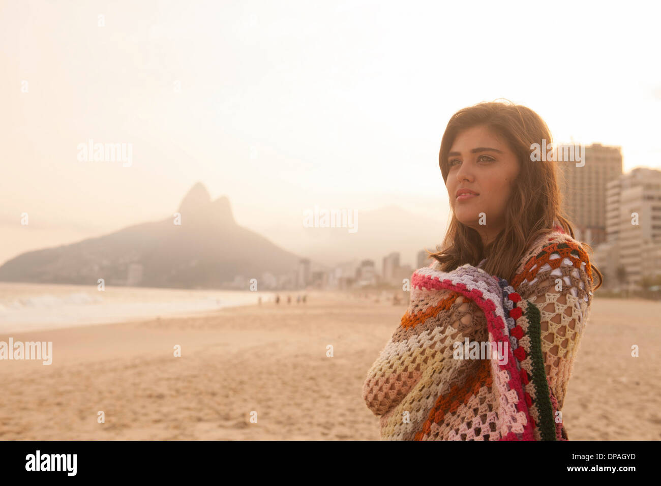 Young woman wrapped in blanket, Ipanema Beach, Rio de Janeiro, Brazil Stock Photo