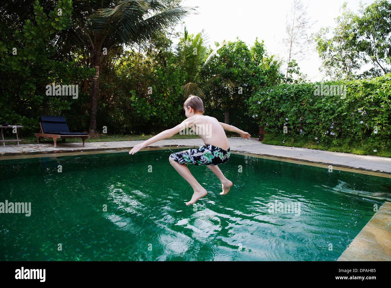 Boy jumping into swimming pool Stock Photo Alamy