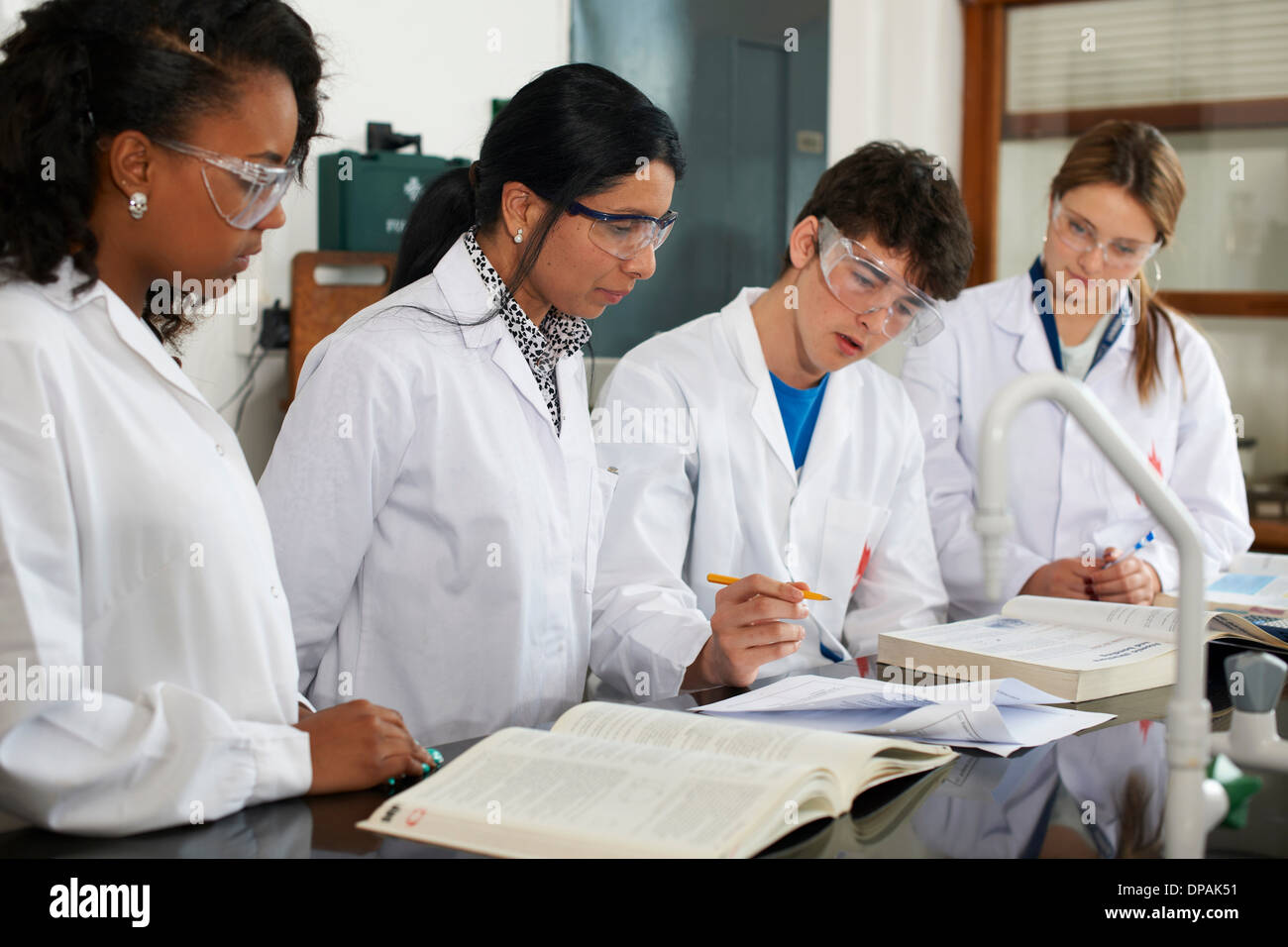 Chemistry teacher and students with text books Stock Photo