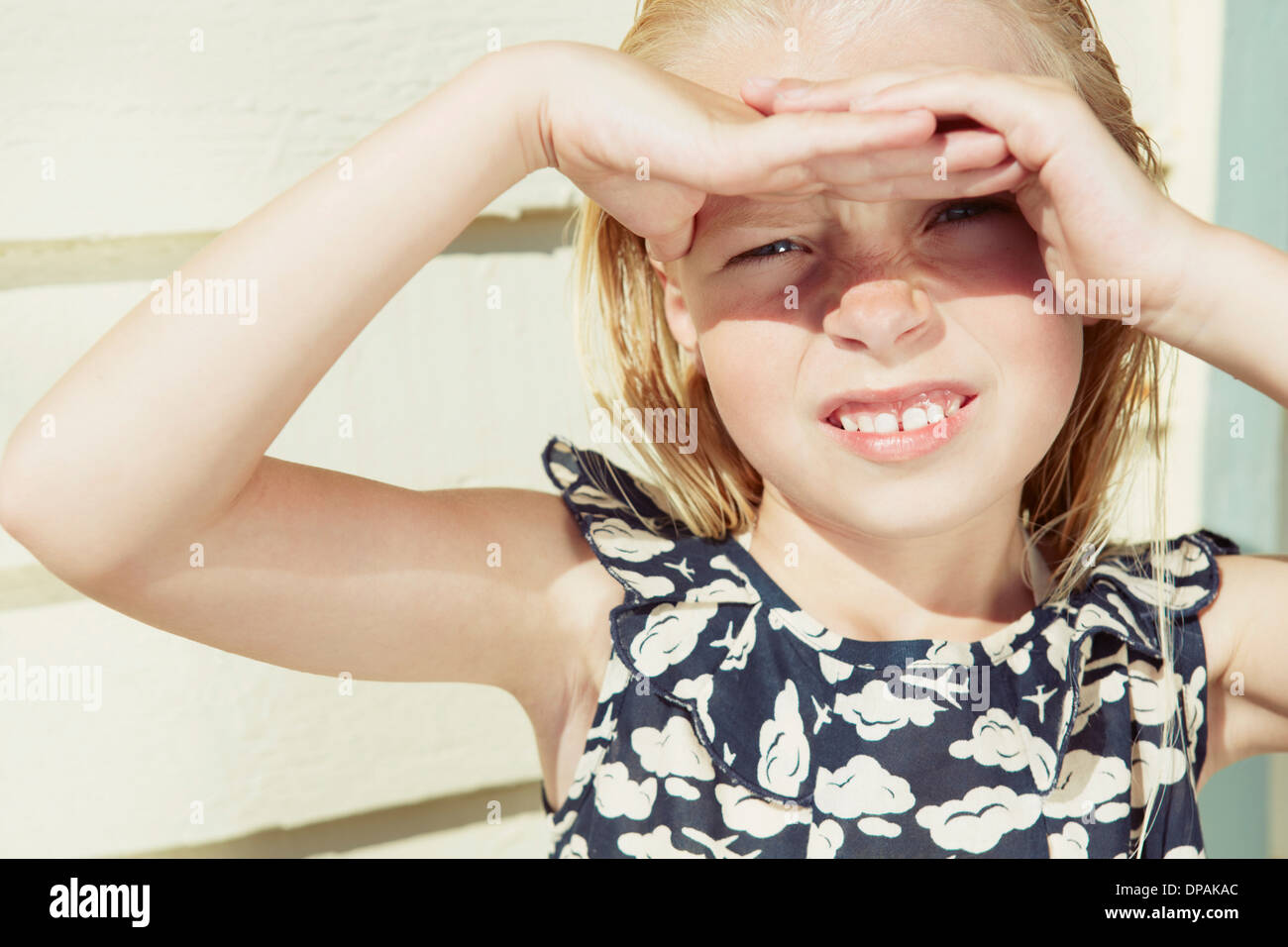 Child covering her eyes from sun glare Stock Photo