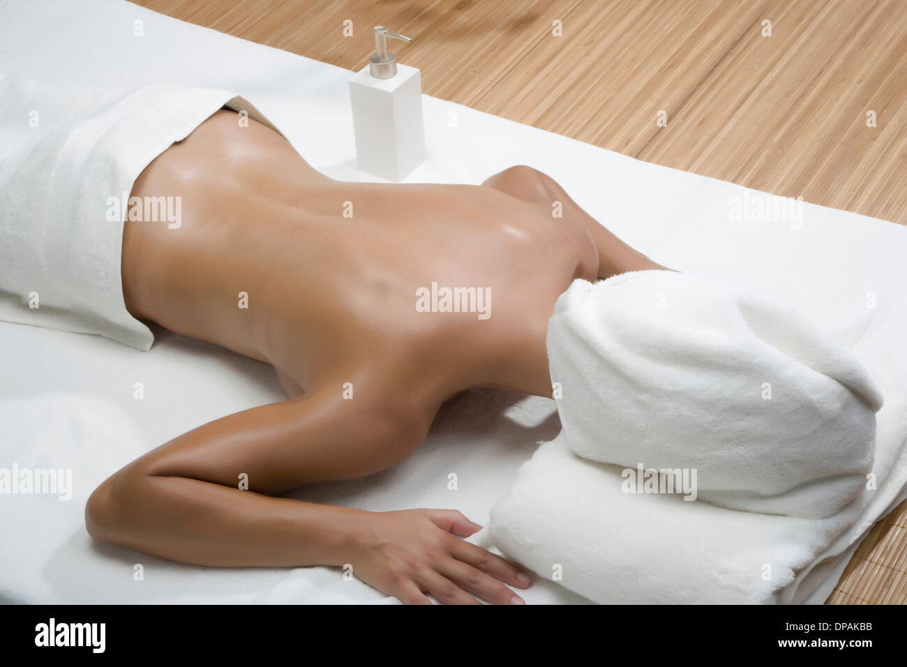 Woman lying in spa with towel covering head Stock Photo