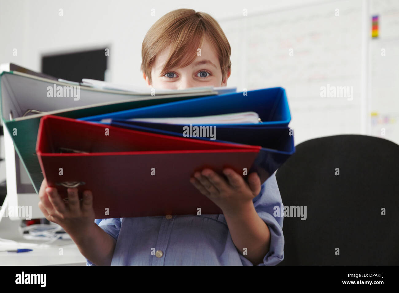 Boy holding pile of ring binders Stock Photo - Alamy